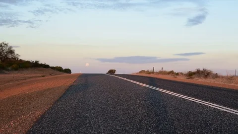 Open road with moon rising in sky after sunset Stock Footage 80128954