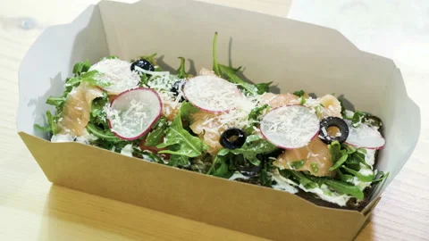 Open sandwich with rye bread, salted salmon, cheese, vegetables and herbs. 4K Stock-Footage 97602530