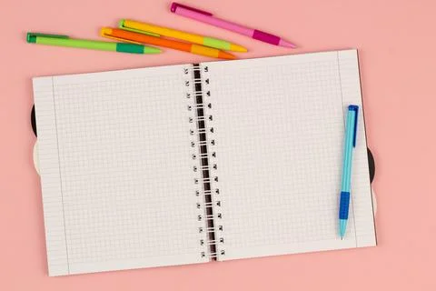 Open school notebook and study pen on the pink background. Top view Stock Photos
