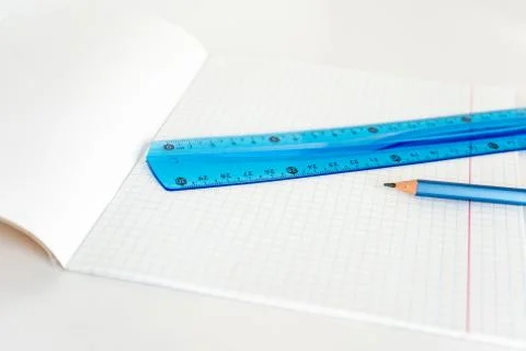 Open school notebook with a simple pencil and a ruler on a white table. back to Stock Photos
