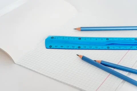 Open school notebook with a simple pencil and a ruler on a white table. back to Stock Photos