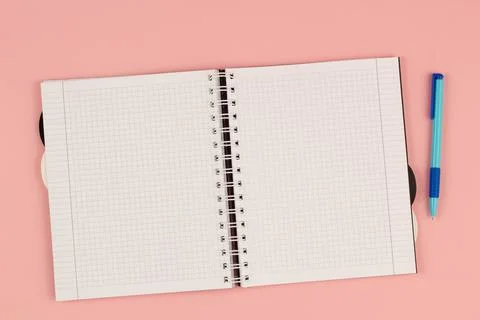 Open school squared notebook and colored rulers on the pink background. Top view Stock Photos