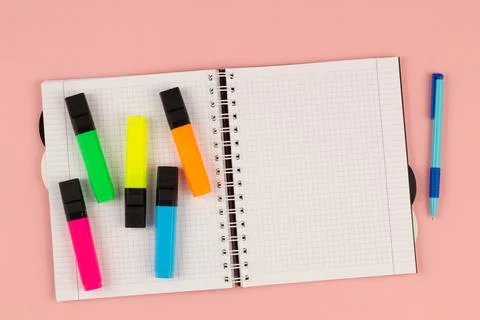 Open school squared notebook and colored rulers on the pink background. Top view Stock Photos