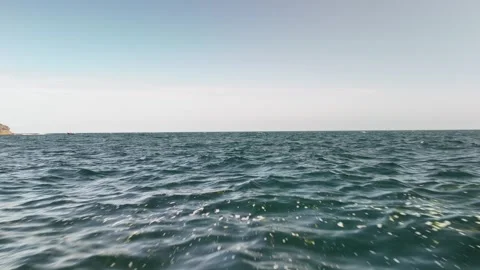 Open Sea with Gentle Waves and Rocky Coast Stockbeeldmateriaal 337848120