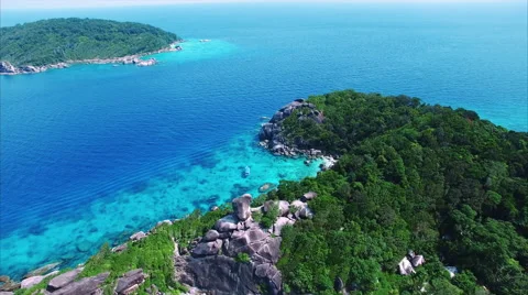 Open sea separates lush granite islets above clear tropical water Stock Footage 60326025
