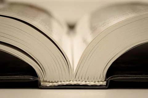 Open shiny book on the table, binding, close-up. Stock Photos