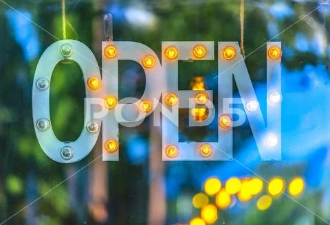 Open sign with out of focus light bulbs Stock Photos
