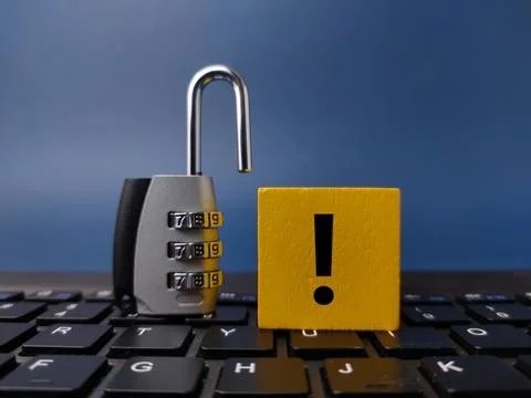 An open silver combination padlock stands on a black computer keyboard next.. 写真素材