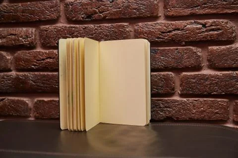 Open sketchbook is on the table. background brick wall Stock Photos