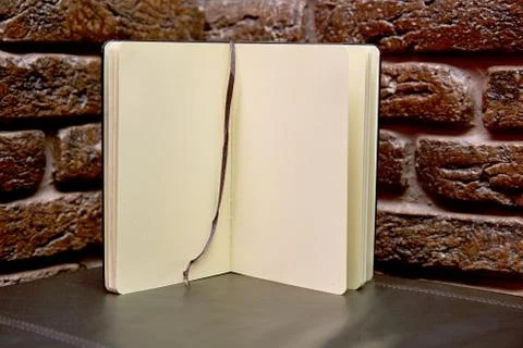 Open sketchbook is on the table. background brick wall Stock Photos