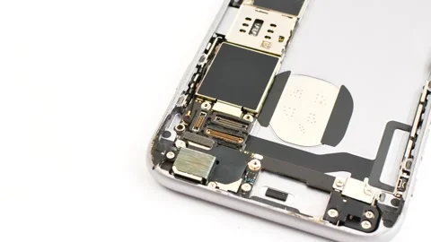 Open smartphone under maintenance on a white surface, revealing its interna.. Stock Footage 261097327