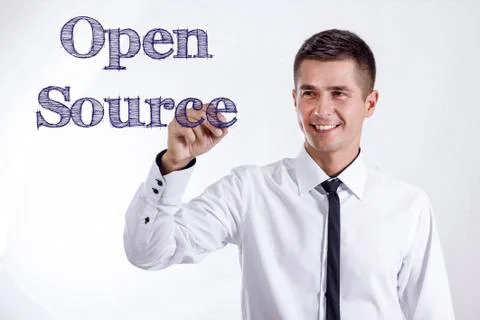 Open Source - Young smiling businessman writing on transparent surface Stock Photos