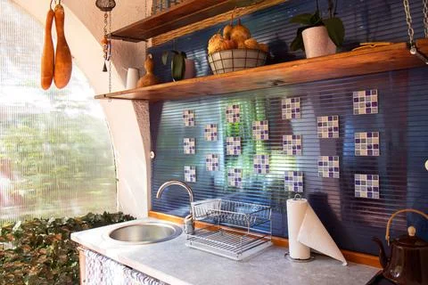 Open space kitchen interior. Sink and shelves with fruits. Rustic style kitch Stock Photos