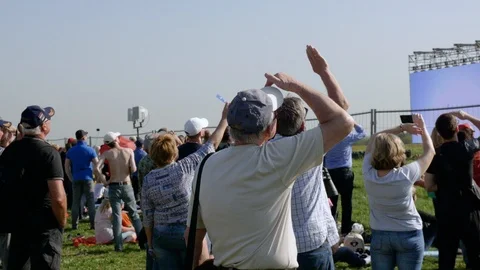 In the open space there are people looking at the sky. Shooting from the back Stock Footage 120174939