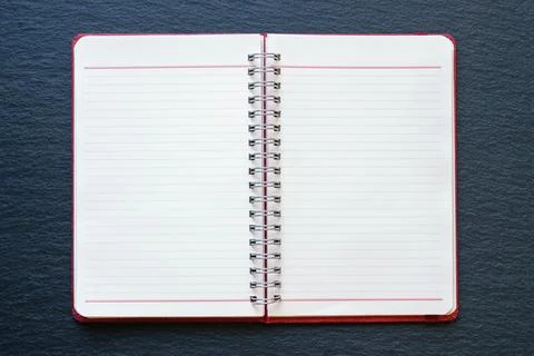 Open spiral bound notebook on black table. Copy space Stock Photos