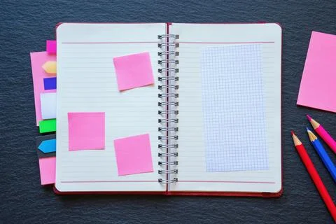 Open spiral bound notebook with blank pages, notes and colorful bookmarks Stock Photos