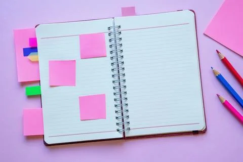 Open spiral bound notebook with blank pages, notes and colorful bookmarks Stock Photos