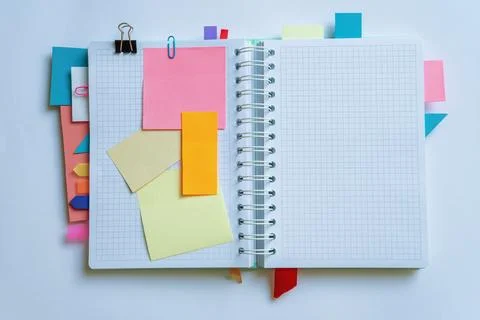 Open spiral bound notebook with notes and colorful bookmarks. Copy space Stock Photos