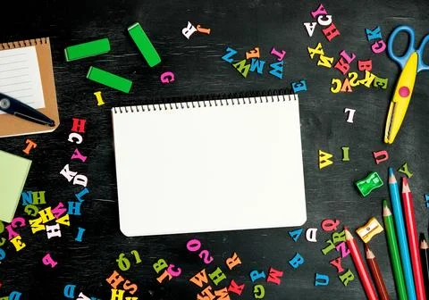 Open spiral notebook with clean white sheets, wooden colored pencils Stock Photos