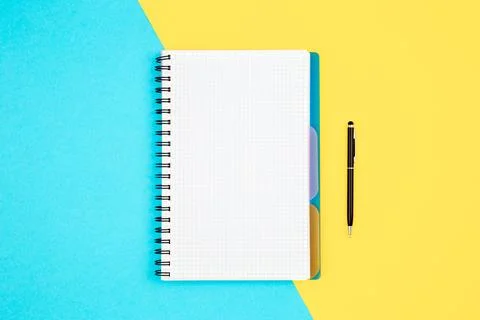 Open spiral notepad on blue yellow background, flat lay. Stock Photos