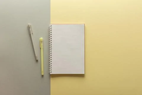 Open spiral notepad on gray and yellow background Stock Photos