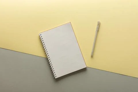 Open spiral notepad on gray and yellow background Stock Photos