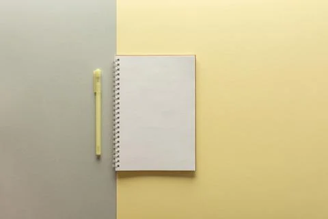 Open spiral notepad on gray and yellow background Stock Photos