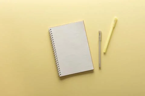 Open spiral notepad on yellow background Stock Photos