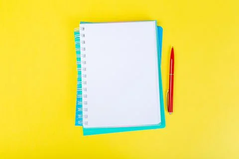 Open spiral notepad on a yellow background with a pen. top view, stack of not Stock Photos