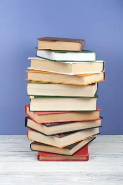 Open stacking book, hardback colorful books on wooden table and blue backgr.. Stock Photos