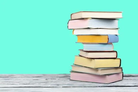 Open stacking book, hardback colorful books on wooden table and green backg.. Foto stock