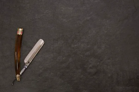 Open straight razor on a gray background with free space on the right Stock Photos