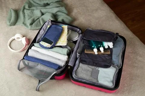 An open suitcase with clothes, documents and accessories for the trip. Foto stock