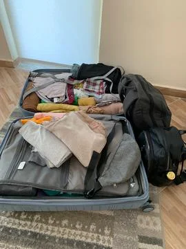 Open Suitcase with Clothes Packed for a Trip Stock Photos