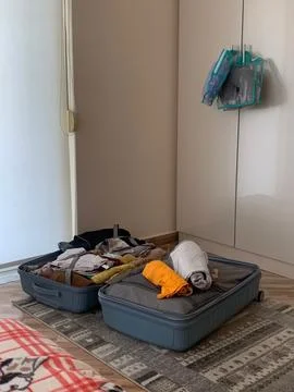 Open Suitcase with Clothes Packed for a Trip Stock Photos