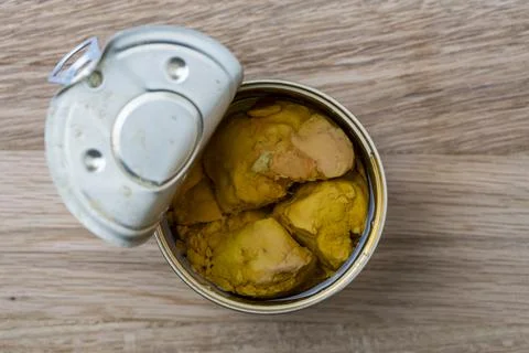 Open tin can of cod liver on wooden table, closeup Stock-Fotos
