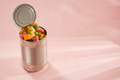 An open tin can filled with raw, diced meat and vegetables 스톡 사진