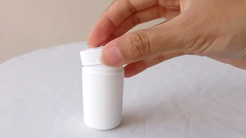 Open up a tiny white jar on a white table Stock Footage 145562621