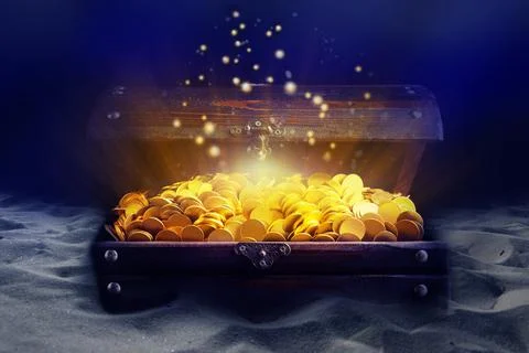 Open treasure chest with gold coins on sand seabed Stock Photos