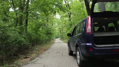 Open trunk and flashing headlights of a car on the side of a country road Stock Footage 207463065