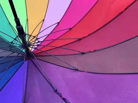 An open umbrella is bright, multi-colored, close-up. Background texture: umbr Stock Photos