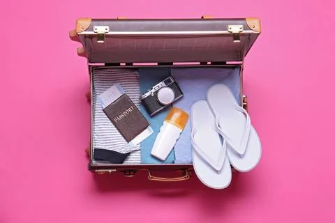 Open vintage suitcase with beach objects on pink background, top view Stock Photos