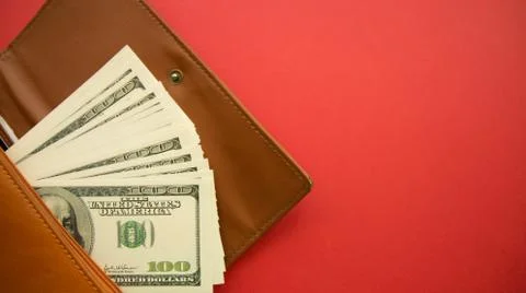 Open a wallet with dollars on a red background, finance theme Stock Photos