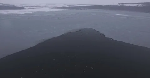 Open water spring of a frozen winter lake, aerial photography Stock Footage 83566785