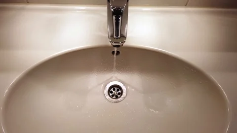 Open water tap in a bathroom Stock Footage 123899569