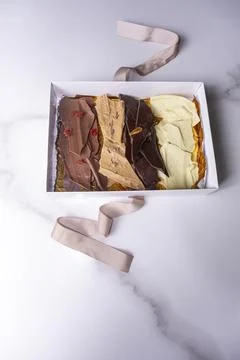 An open white box with assorted chocolate chips vertical. Stock Photos