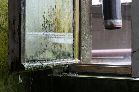 Open window in abandoned building during rainfall Fotos de archivo