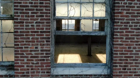 An open window and missing glass panes at old brick factory building, now Stock Footage 122089947