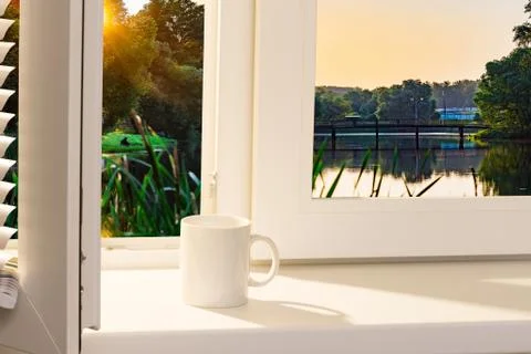 Open window with a cup on the windowsill. Foto stock