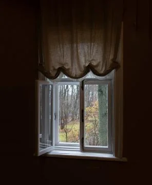 Open window in a dark room overlooking the autumn forest Stock Photos
